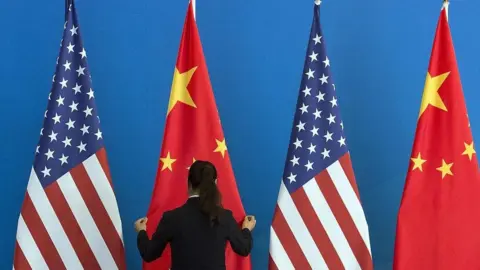 Getty Images A woman sets up Chinese and US flags in Beijing, 2014