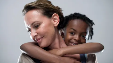 Getty Images White woman with black child