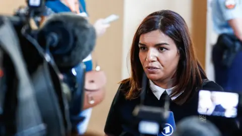 Mouna Rhabi (C), a survivor from the Nice attack, talks to press, next to a temporary courtroom at the opening day of the Nice truck attack trial case