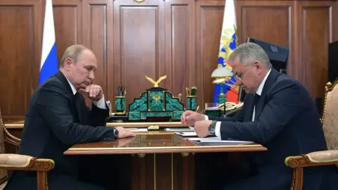 EPA Russian president Vladimir Putin (L) listens to a report of Defence Minister Sergei Shoigu (R)