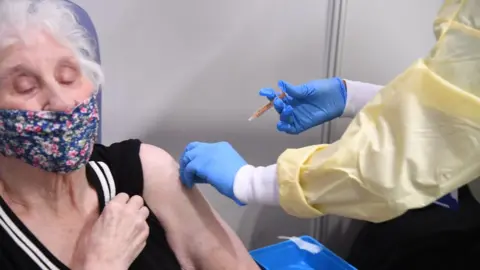 PA Media Woman receiving Covid vaccine