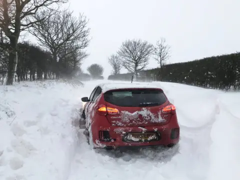 Victoria Lawrence via PA Media Handout photo of a car stuck in the snow at Southrepps in Norfolk, on 8 February 2021