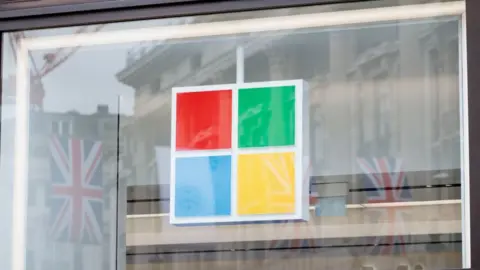 Getty Images Union Jack flags reflected in the window of the Microsoft Experience Centre in London, England