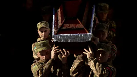 Reuters Ukrainian servicemen carry a coffin during a funeral ceremony