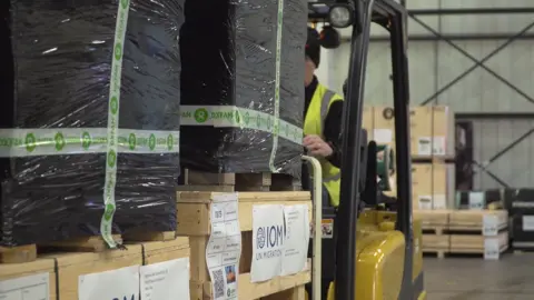 Ryan Witchalls/Oxfam Loading aid pallets in warehouse