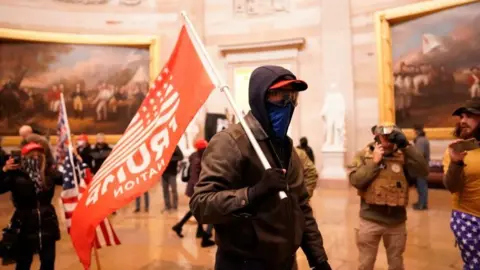 Getty Images Rioter in the capitol rotunda with Trump flag