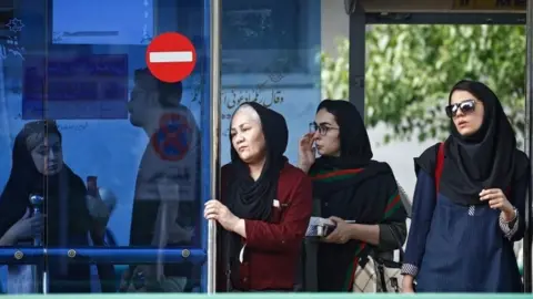 EPA Iranian women wait in a bus station on the eve of first anniversary of US withdrawal from nuclear deal, in a street of Tehran, Iran, 7 May 2019.