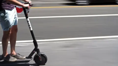 Getty Images A person riding an e-scooter