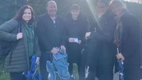 BBC/Daniel Sexton A family holding tickets for the match and chairs