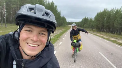 Two lads smiling and cycling