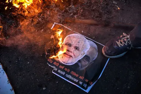 Getty Images Activists of the Indian Youth Congress burn a poster with images of Indian prime minister Narindra Modi and Pakistan prime minister Nawaz Sharif during Modi's visit to Pakistan, on December 25, 2015