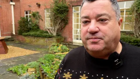 Kevin Small looking at the camera at the back of the civic offices