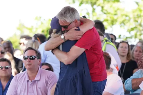 PA Media Barnaby Webber's father David embraces Grace O'Malley Kumar's mother ahead of a vigil at the University of Nottingham