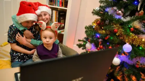 Getty Images Children next to Christmas tree