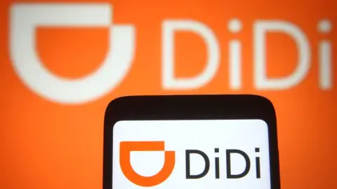 Getty Images DiDi logo on a smartphone and a PC screen.