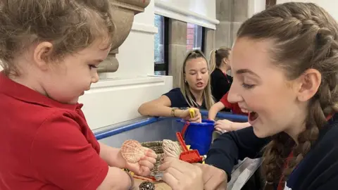 BBC/Vanessa Clarke Woman talking to child at a nursery