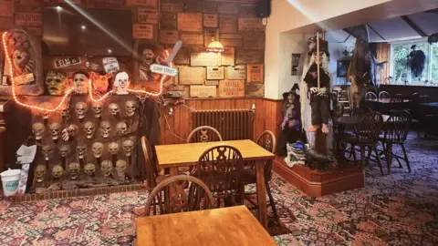 Leeann Austin/PA Wire The hotel dining room with spooky lights, faces and a model of a waitch