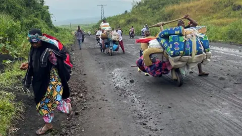 Reuters Civilians flee an advance by M23 rebels in DR Congo