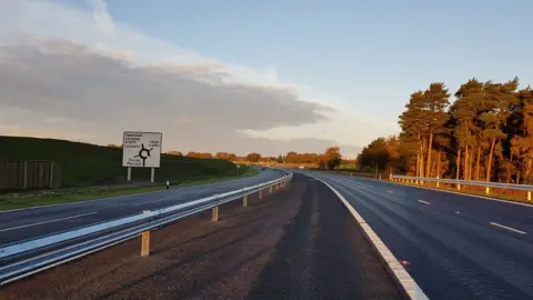 A stretch of the NDR, with a sign warning of a roundabout ahead