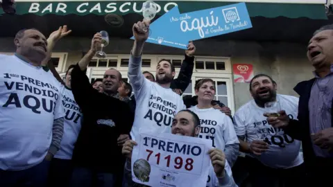 Reuters People, who bought winning tickets of the biggest prize of Spain's Christmas Lottery, celebrate in Vilalba