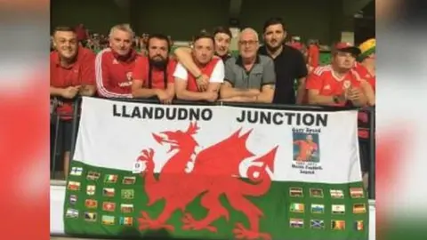 Brad Evans Brad Evans and fellow Wales fans from Llandudno Junction with the flag that's travelled to every Wales match