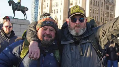 PA Media Tim Edwards (right) with comedian John May in Liverpool