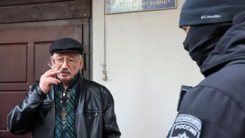 Reuters Oleg Orlov, co-chair of the Memorial rights group, smoking a cigarette as he is taken to the Russian Investigative Committee in Moscow