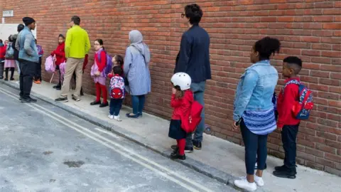 Dominic Lipinski/PA Wire pupils queueing to return to school