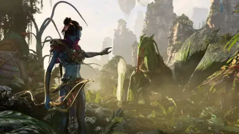 A blue-skinned alien from the Avatar film series stretches a hand out to a flying animal in this game screenshot