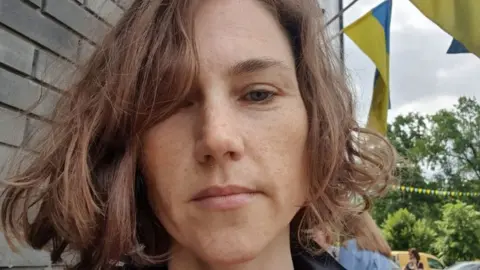 Anna Woman with Ukrainian flags behind her