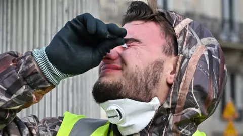 Getty Images A protester puts in eyedrops after French police used tear gas in Paris