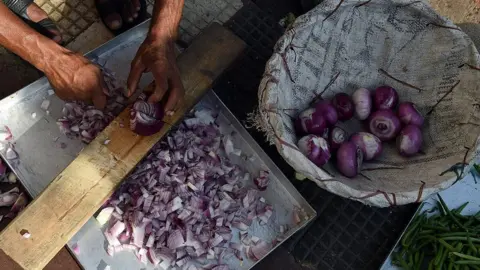 Getty Images An Indian restaurant worker cuts onions for curries in New Delhi on September 11, 2015.