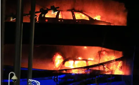 Reuters Cars on fire in the car park