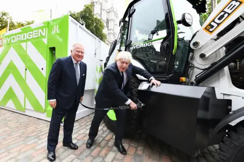JCB Prime Minister Boris Johnson refuels JCB's prototype hydrogen powered backhoe loader