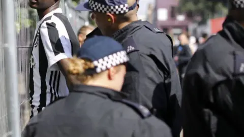 AFP/Getty Images File image of an anonymous black man being stopped and searched by police at Notting Hill Carnival