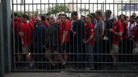 PA Media Fans waiting outside the gates to enter the stadium as kick off is delayed before the UEFA Champions League Final at the Stade de France