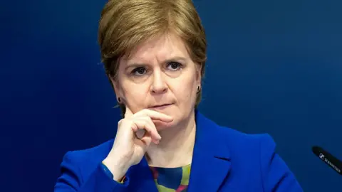 Nicola Sturgeon stands at a podium