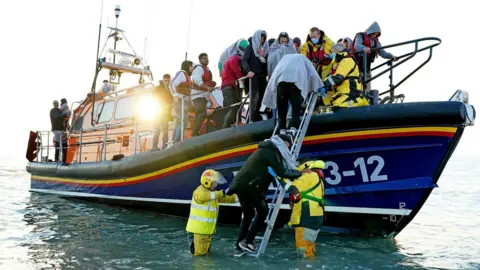 PA Media Migrants are brought to Dungeness by the RNLI after a small boat incident in the Channel