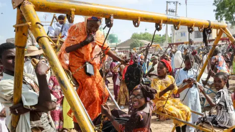 Getty Images Children on swings at an amusement park in Kano, Nigeria - Monday 11 July 2022