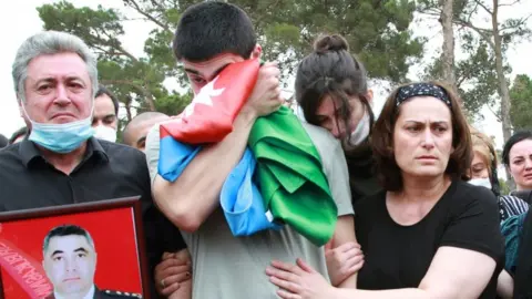 Reuters Mourners gather at the grave of an Azeri killed in border fighting with Armenia