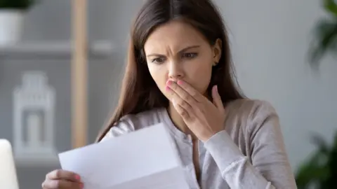 Getty Images Woman shocked at letter