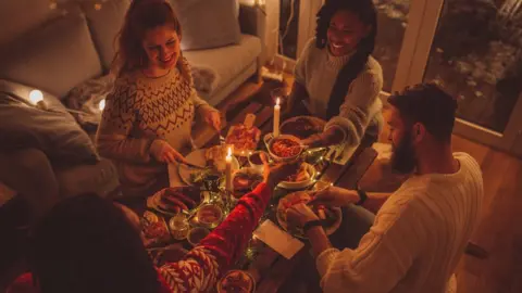 Getty Images Friends have Christmas dinner at home (generic image)