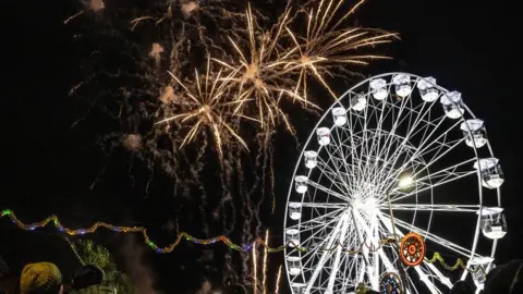 Beth Walsh Fireworks over a big wheel at the celebration