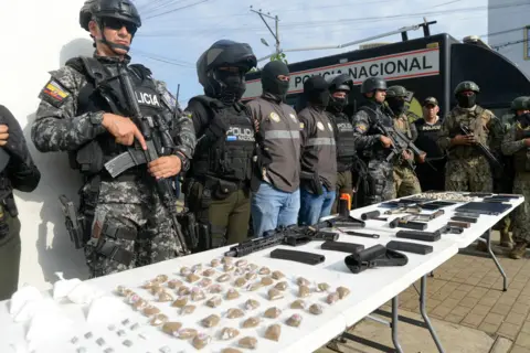 Getty Images Policemen display seized drugs, weapons and phones after a joint operation with members of the military at the Socio Vivienda neighbourhood in Guayaquil, March 2024
