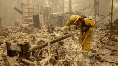EPA A firefighter examines wreckage in Berry Creek, California. Photo: 12 September 2020