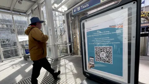 PA Media man beside timetable sign