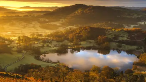 Getty Images Small lake surrounded by hills with sunrise