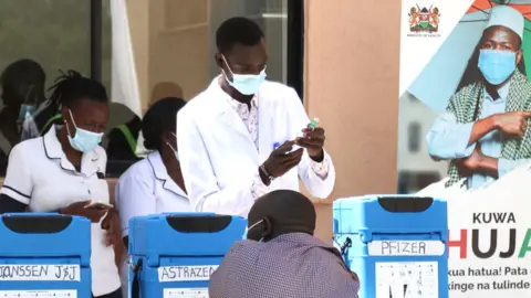Getty Images A medical officer is seen preparing to administer a covid-19 vaccine jab to a man at The Nakuru County Referral and Teaching Hospital. In May 2022