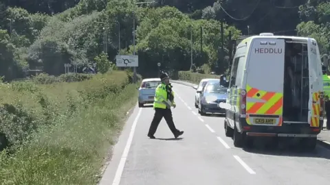 North Wales Police/Twitter Police officers stopping traffic