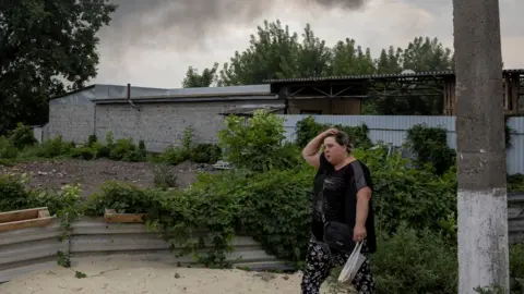 Reuters A woman walks past the market after shelling in Slovyansk